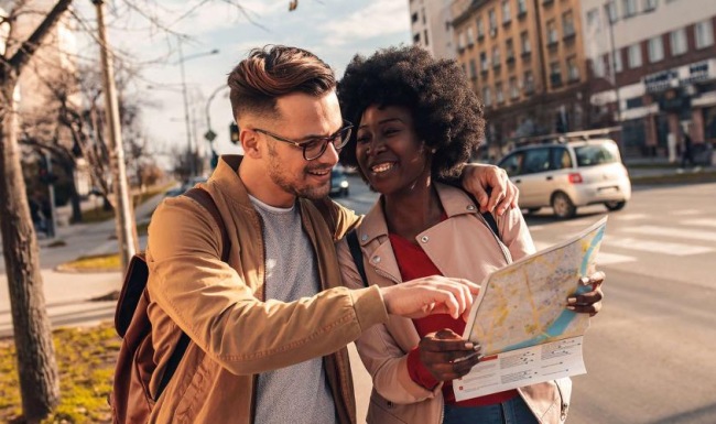 a man and woman looking at a map in the city